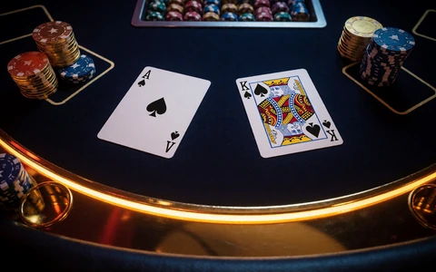 Blackjack-Tisch mit Ass und K&ouml;nig sowie goldenen Casino-Chips bei 30bet Online Casino